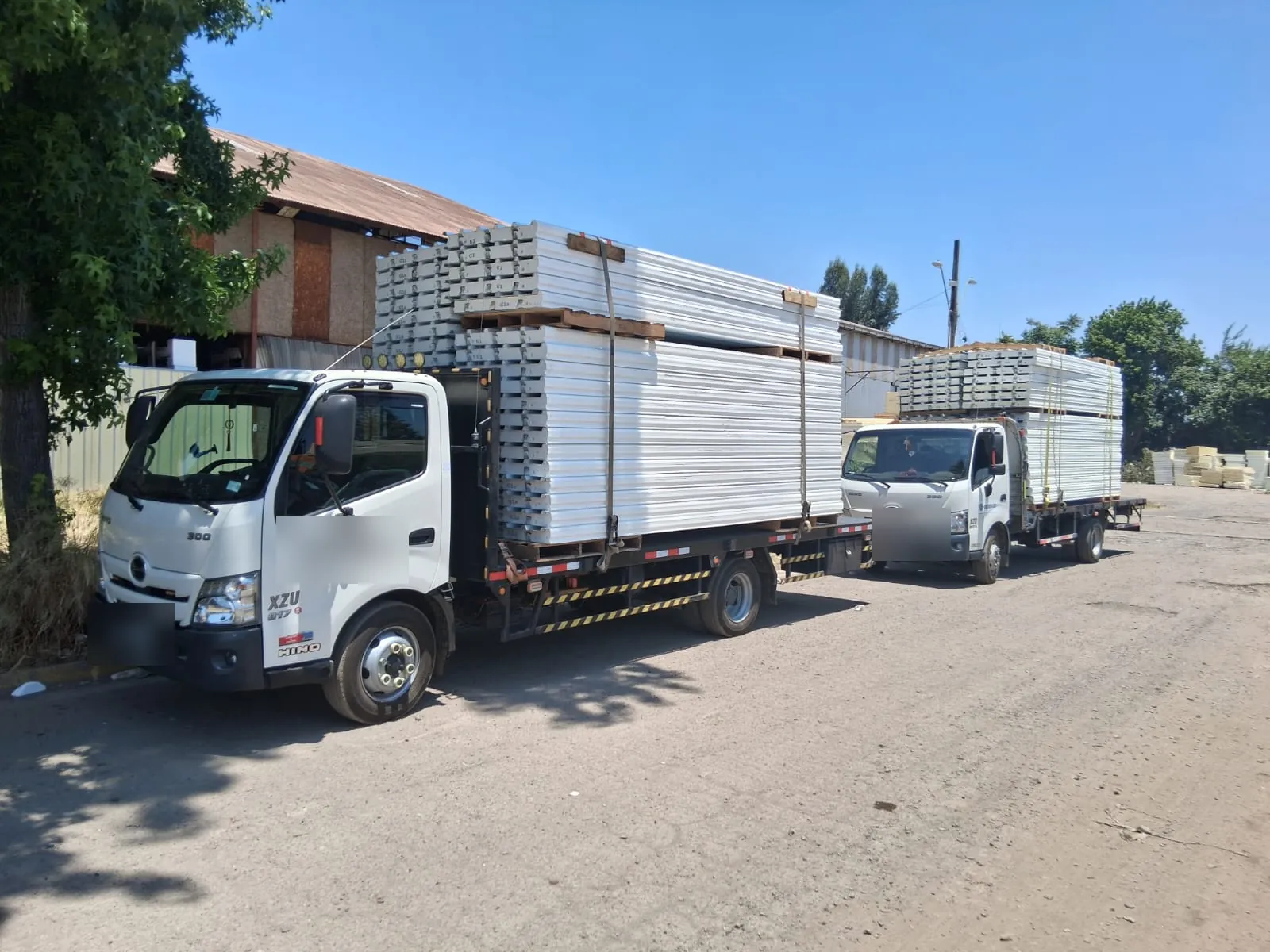Camiones planos cargados con estructura metálica y perfiles